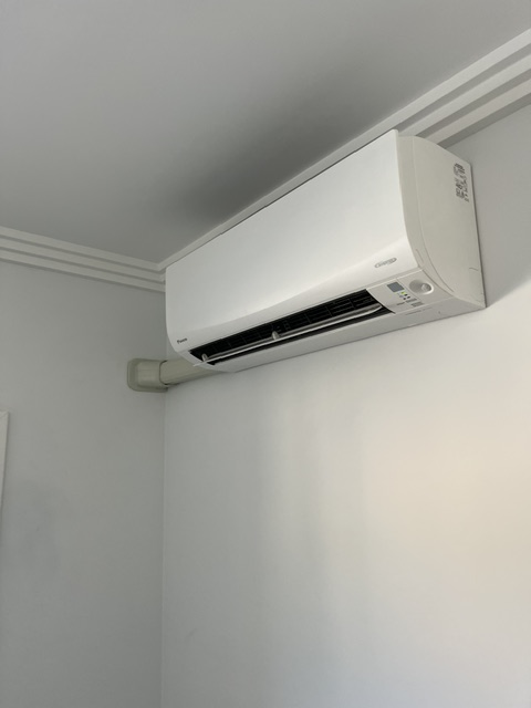Wall-mounted split system beneath ceiling cornicing, photographed on a Murphy Air project.